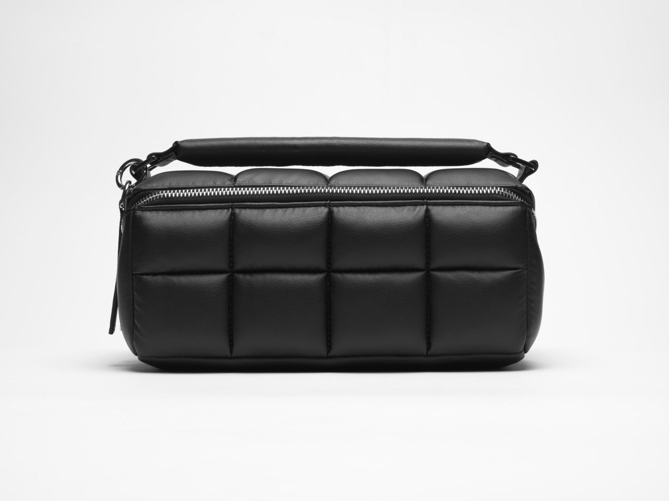 A black makeup bag with a quilted design, featuring a main zipper compartment, multiple internal pockets, and a flat base when opened.