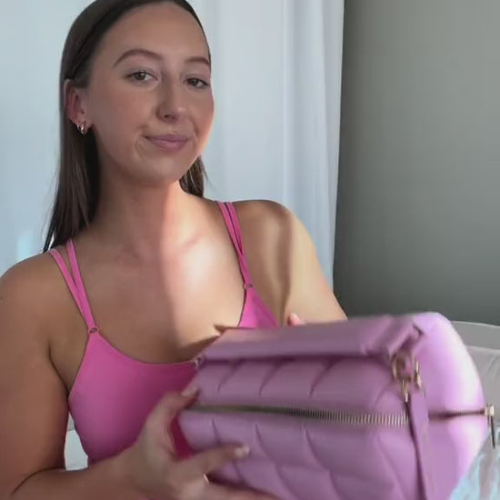 Model in a video showing the HOMEE beauty bag with a model in pink activewear