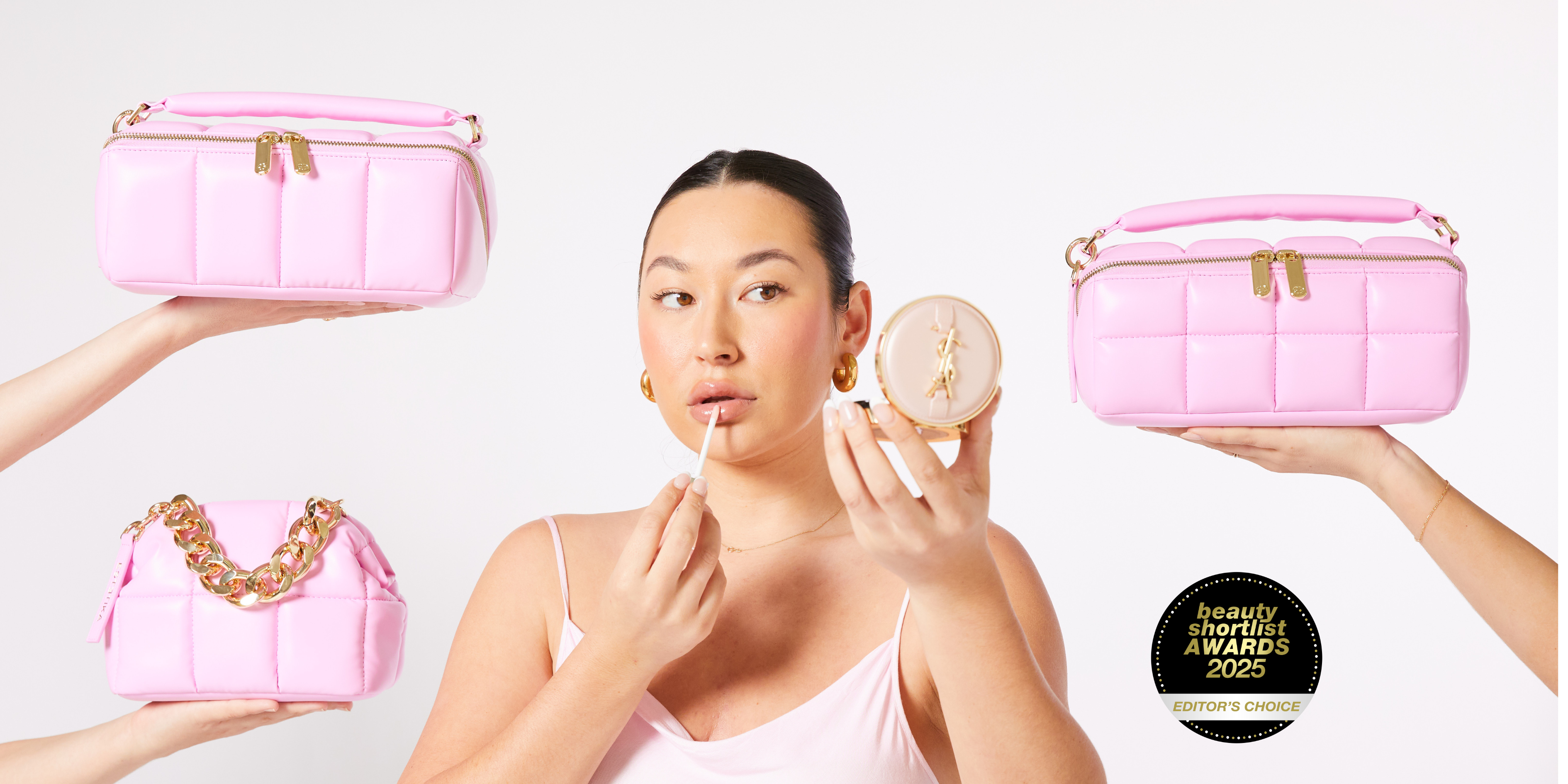 Woman applying makeup with pink cosmetic bags and a product labeled 'Beauty & Grooming Awards' in the background.